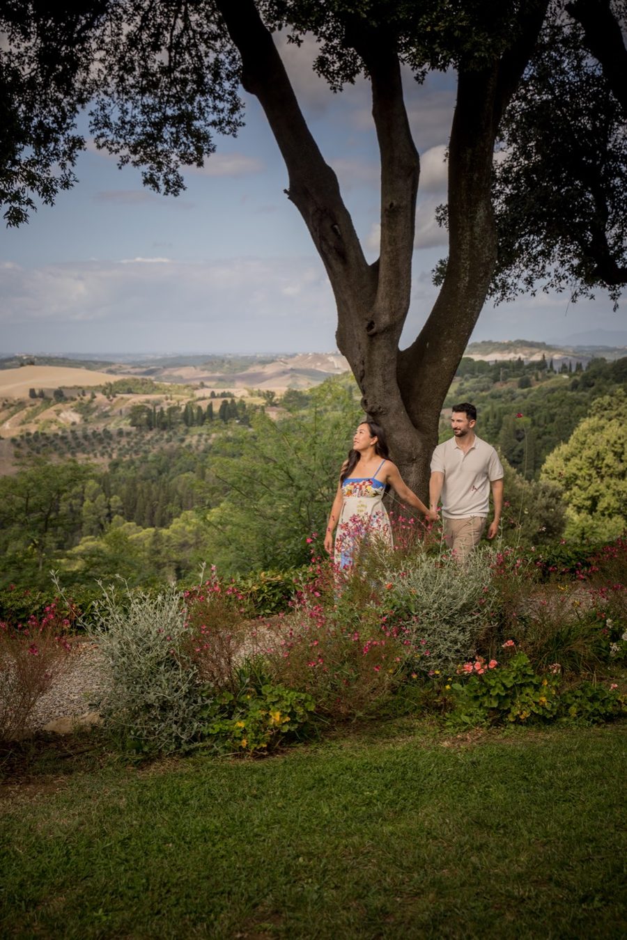 Jennifer and Anthony walking through a hilltop garden in bloom